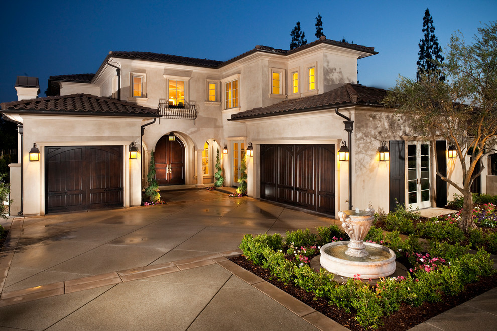 This is an example of a mediterranean two-storey beige exterior in Los Angeles with a hip roof and a tile roof.