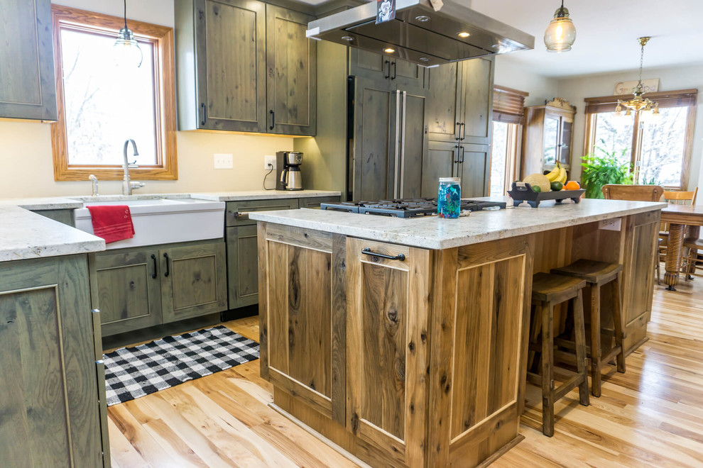 Large mountain style light wood floor and brown floor open concept kitchen photo with beaded inset cabinets, distressed cabinets, granite countertops, an island and white countertops