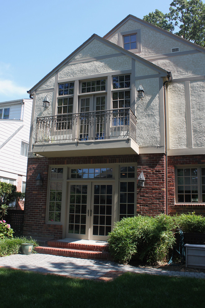 Traditional multi-coloured house exterior in New York with a gable roof and a shingle roof.