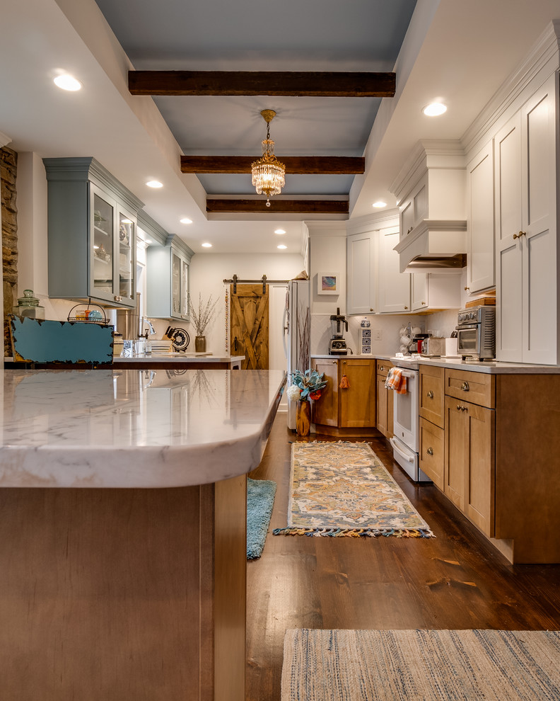 Large country l-shaped separate kitchen in Philadelphia with glass-front cabinets, blue cabinets, quartzite benchtops, white splashback, white appliances, dark hardwood floors, a peninsula and white benchtop.