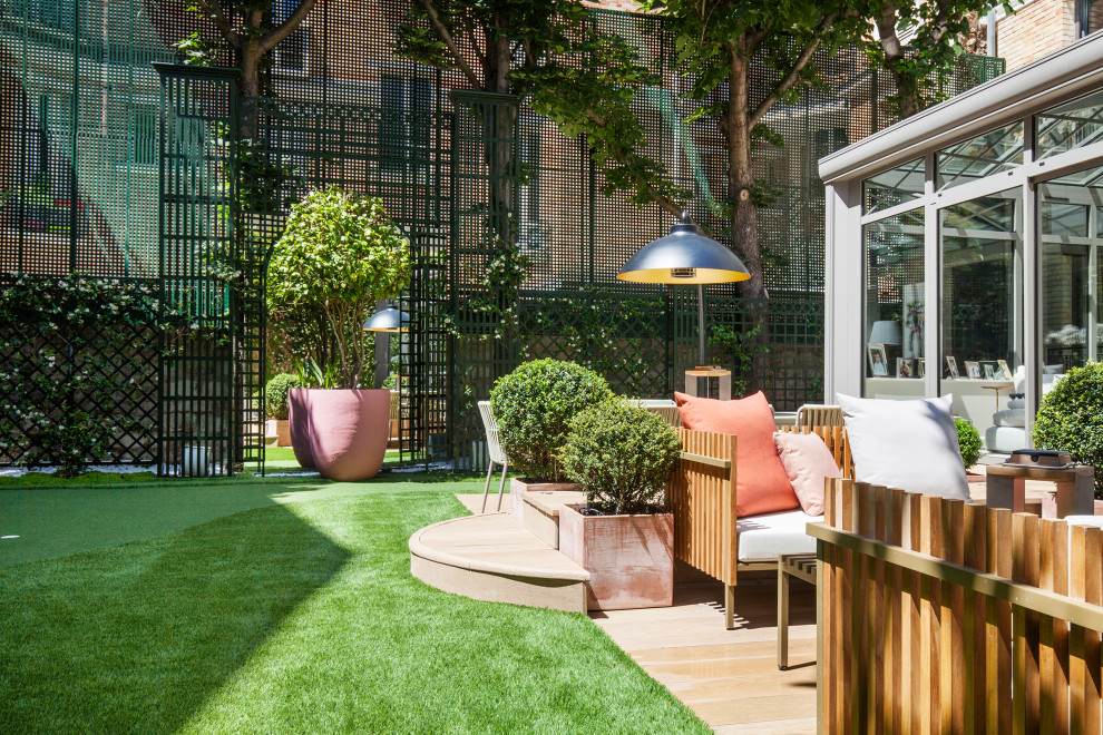 This is an example of a mid-sized modern backyard partial sun garden in Paris with a container garden and decking.
