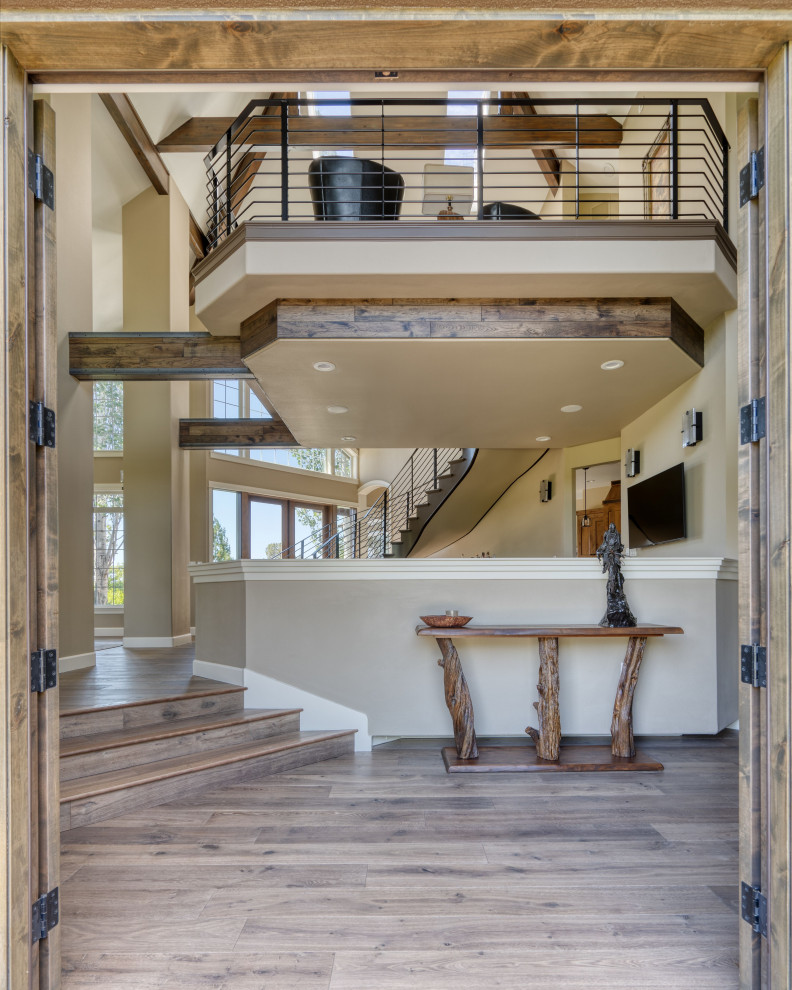 Inspiration for a front door in Los Angeles with beige walls, light hardwood floors, a double front door and exposed beam.