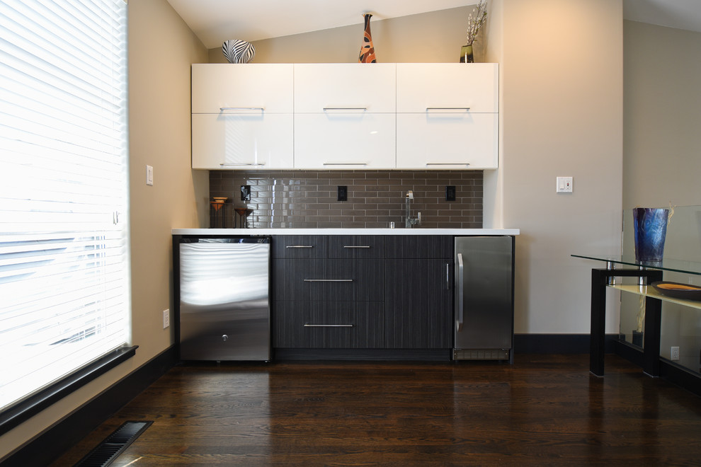Photo of a small contemporary single-wall wet bar in San Francisco with an undermount sink, white cabinets, solid surface benchtops, brown splashback, ceramic splashback and dark hardwood floors.