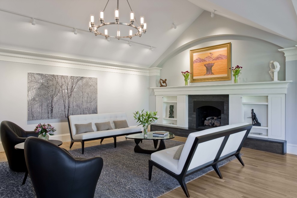 This is an example of a mid-sized contemporary formal open concept living room in Boston with white walls, a standard fireplace, light hardwood floors, a tile fireplace surround, no tv and brown floor.