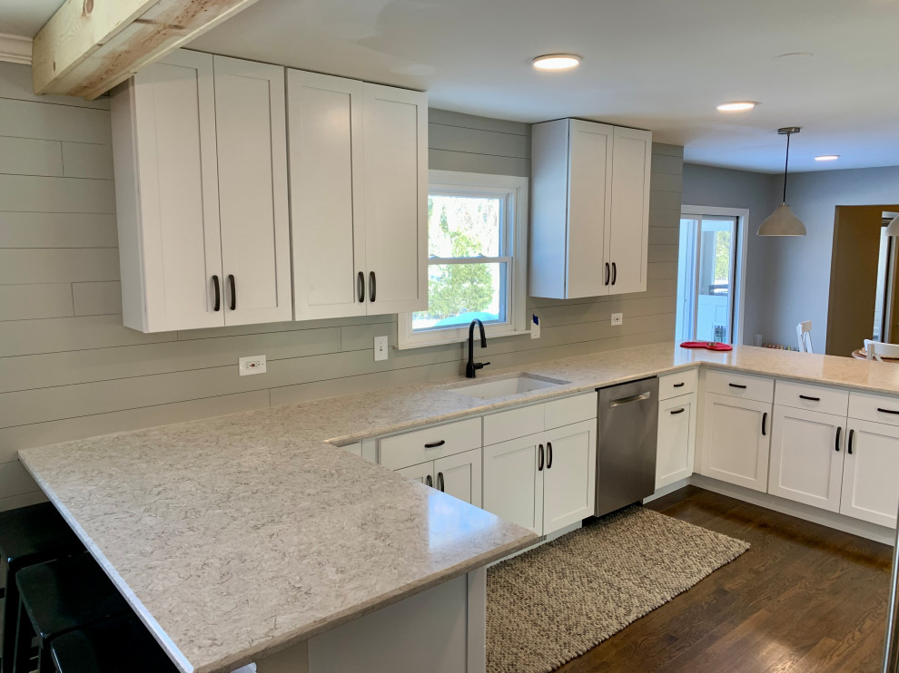 Design ideas for a large modern u-shaped eat-in kitchen in Chicago with an undermount sink, shaker cabinets, white cabinets, quartz benchtops, grey splashback, timber splashback, stainless steel appliances, dark hardwood floors, a peninsula, brown floor, beige benchtop and timber.
