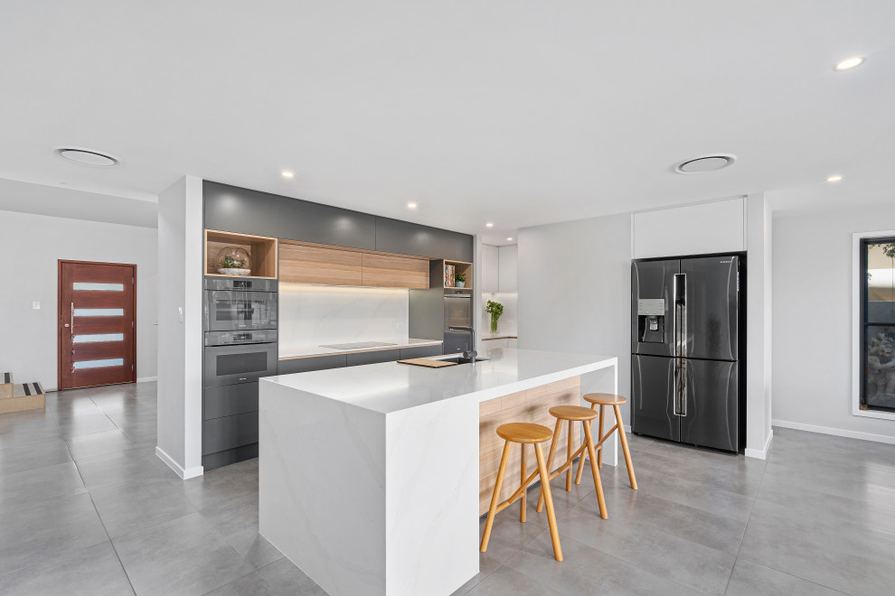 Design ideas for a mid-sized modern l-shaped kitchen pantry in Gold Coast - Tweed with an undermount sink, flat-panel cabinets, grey cabinets, quartz benchtops, white splashback, stone slab splashback, coloured appliances, porcelain floors, with island, grey floor and white benchtop.