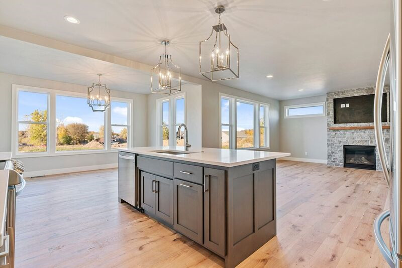 Example of a transitional l-shaped light wood floor eat-in kitchen design with an undermount sink, shaker cabinets, gray cabinets, quartz countertops, white backsplash, mosaic tile backsplash, stainless steel appliances, an island and white countertops