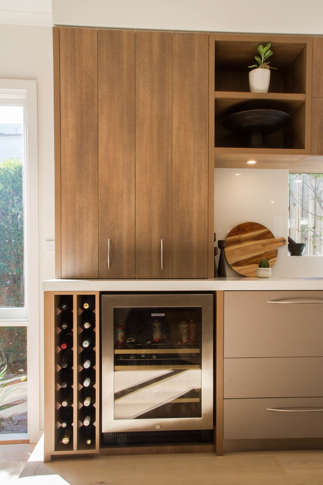Large contemporary l-shaped open plan kitchen in Melbourne with flat-panel cabinets, quartz benchtops and with island.