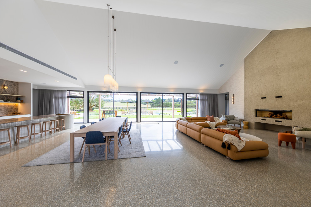 Источник вдохновения для домашнего уюта: огромная открытая гостиная комната в стиле модернизм с серыми стенами, бетонным полом и стандартным камином