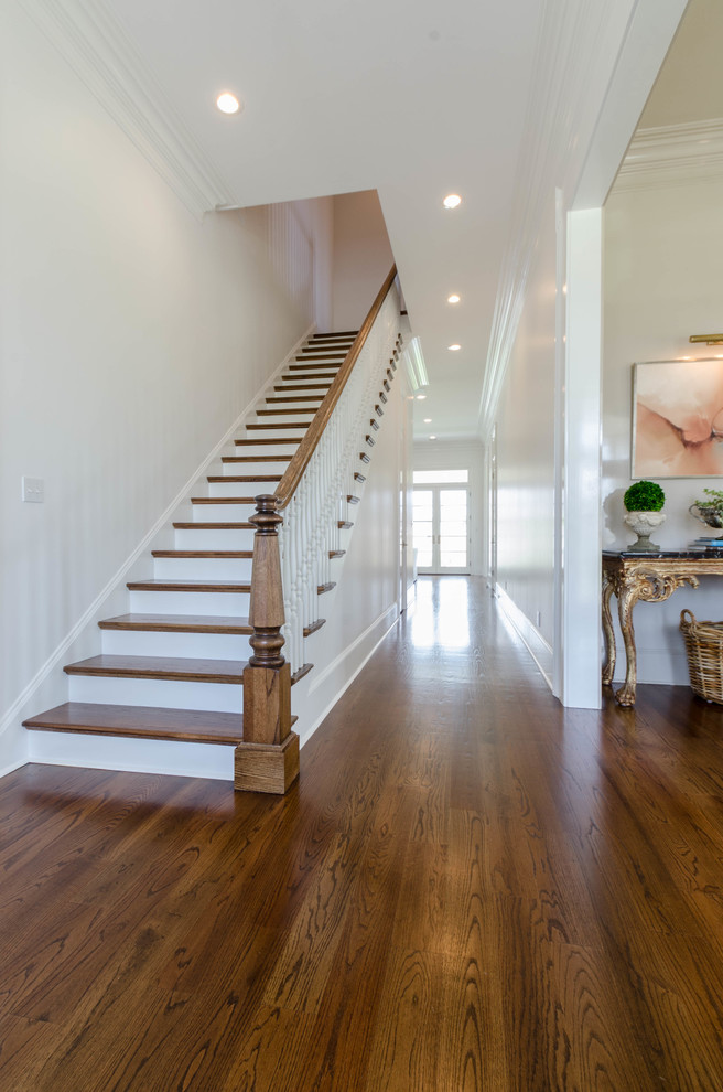 Design ideas for a mid-sized traditional hallway in New Orleans with white walls and dark hardwood floors.