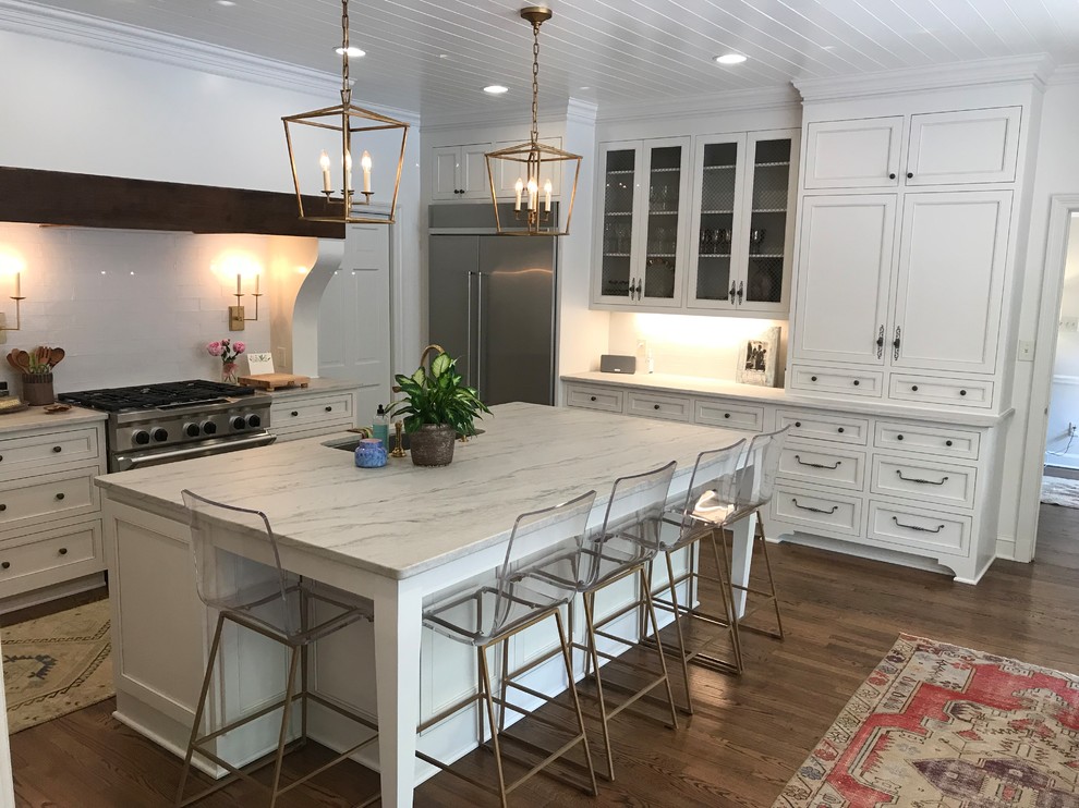 Large transitional u-shaped dark wood floor and brown floor eat-in kitchen photo with recessed-panel cabinets, white cabinets, marble countertops, white backsplash, subway tile backsplash, stainless steel appliances, an island, white countertops and an undermount sink