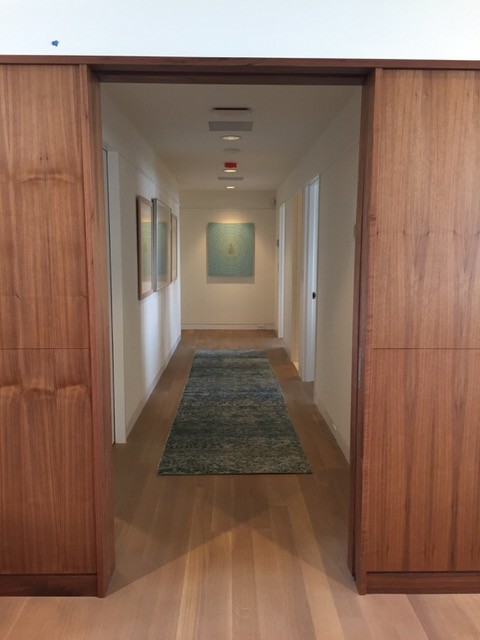 Photo of a mid-sized midcentury hallway in DC Metro with white walls and light hardwood floors.