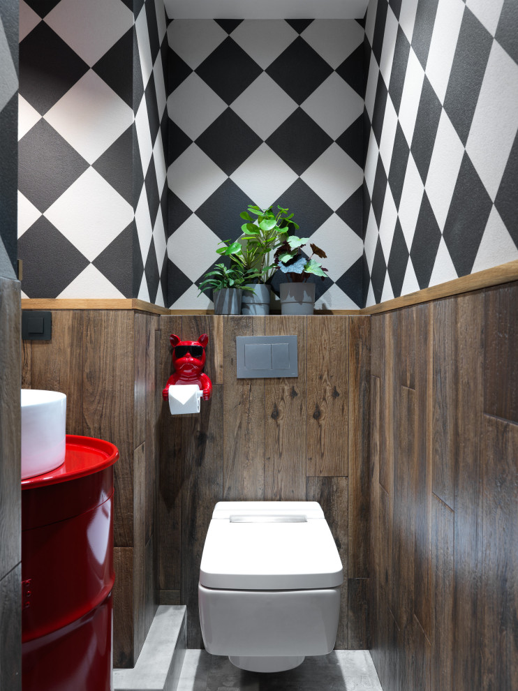 Пример оригинального дизайна: маленький туалет: освещение в стиле лофт с плоскими фасадами, красными фасадами, инсталляцией, коричневой плиткой, керамогранитной плиткой, коричневыми стенами, полом из керамогранита, накладной раковиной, столешницей из цинка, серым полом, красной столешницей, напольной тумбой и обоями на стенах для на участке и в саду