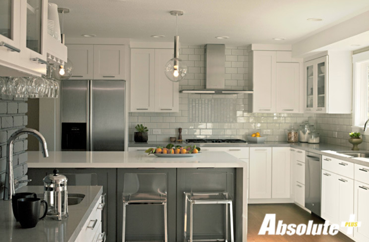 Transitional medium tone wood floor kitchen photo in New York with an undermount sink, shaker cabinets, white cabinets, quartz countertops, gray backsplash, glass tile backsplash and an island