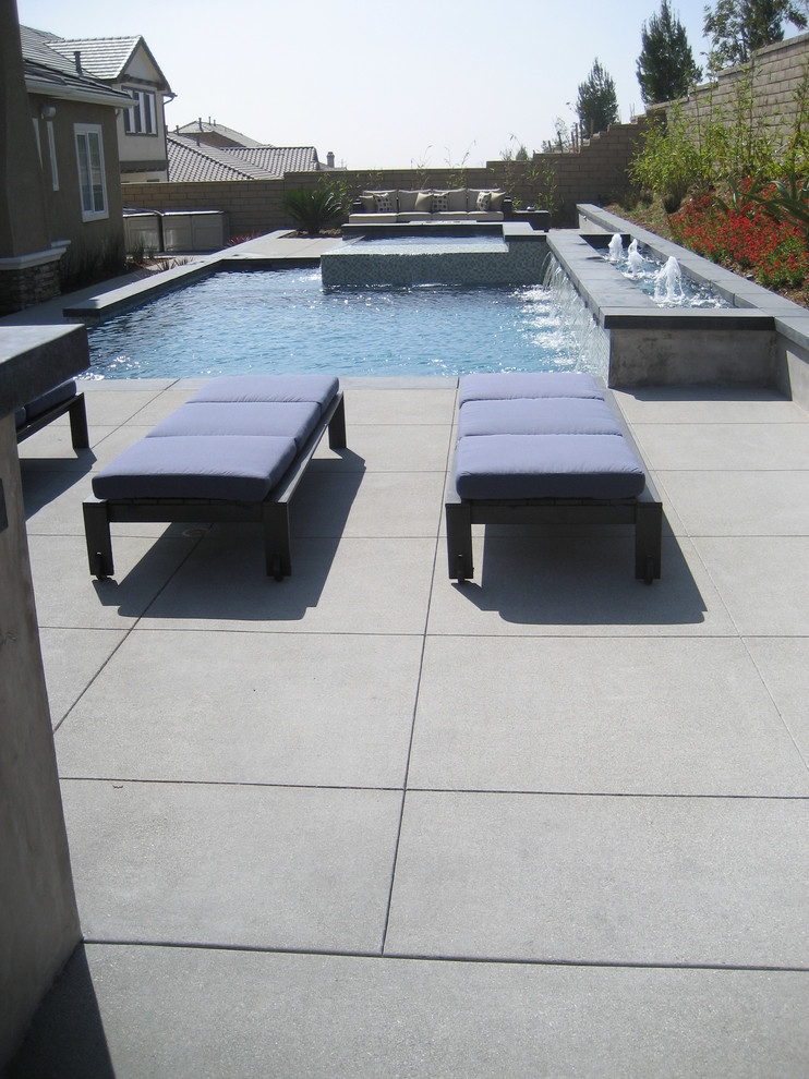 Photo of a mid-sized asian backyard custom-shaped aboveground pool in Orange County with a hot tub and concrete slab.