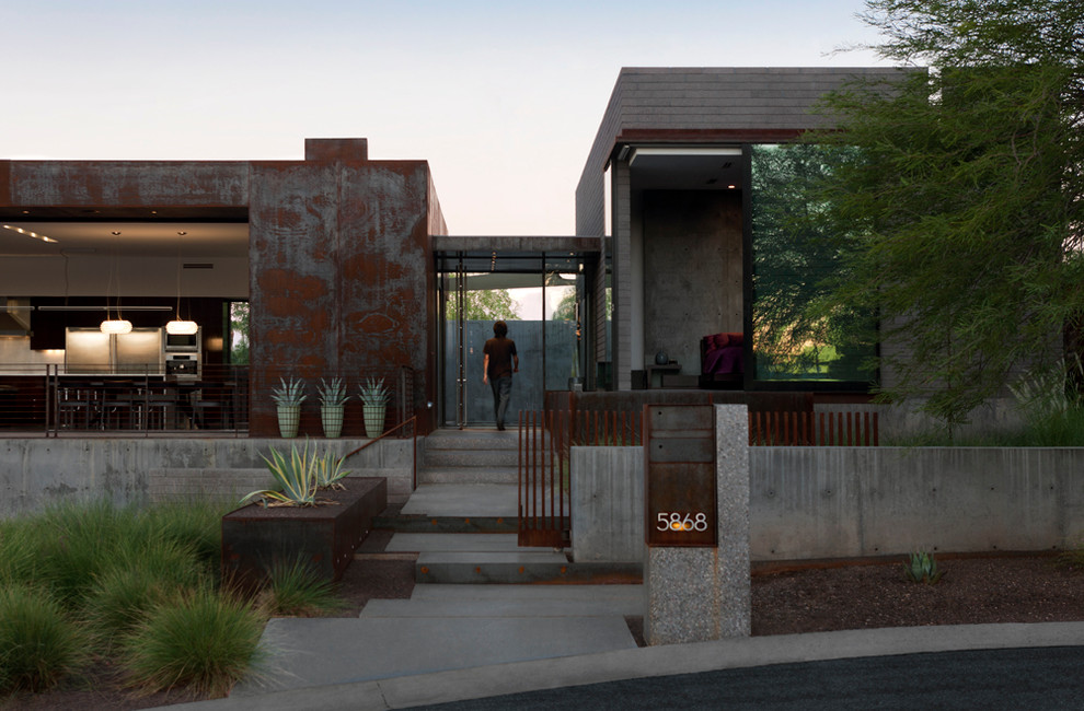 Mid-sized modern split-level grey exterior in Phoenix with metal siding and a flat roof.