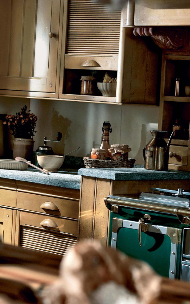 Exempel på ett mellanstort lantligt grå grått kök, med vitt stänkskydd, vitt golv, en rustik diskho, luckor med glaspanel, gula skåp, granitbänkskiva, stänkskydd i skiffer, färgglada vitvaror, cementgolv och en köksö