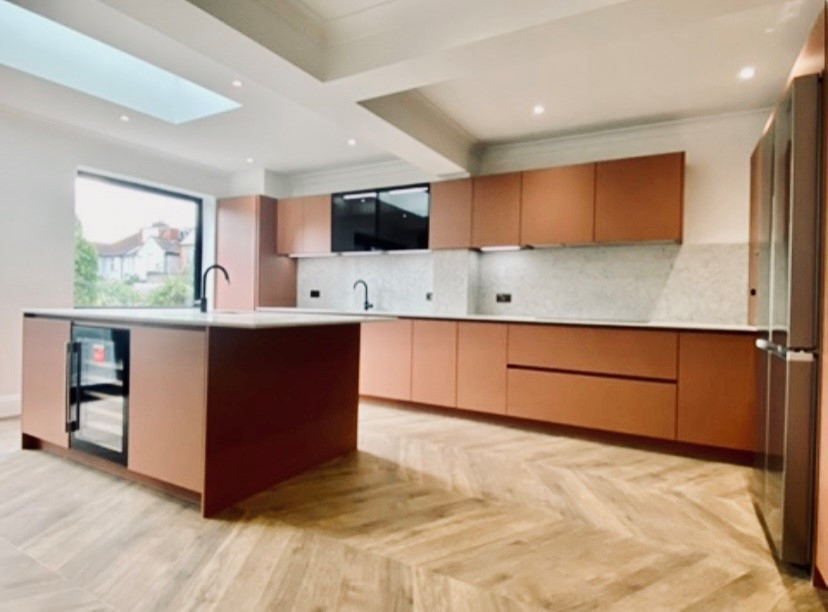 Eat-in kitchen - mid-sized modern l-shaped vinyl floor, brown floor and vaulted ceiling eat-in kitchen idea in Essex with an integrated sink, flat-panel cabinets, red cabinets, granite countertops, gray backsplash, granite backsplash, paneled appliances, an island and gray countertops