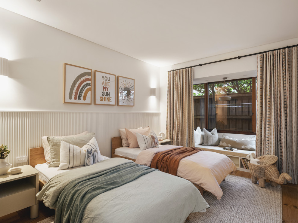 Contemporary gender-neutral kids' bedroom in Sydney with white walls, medium hardwood floors and brown floor.