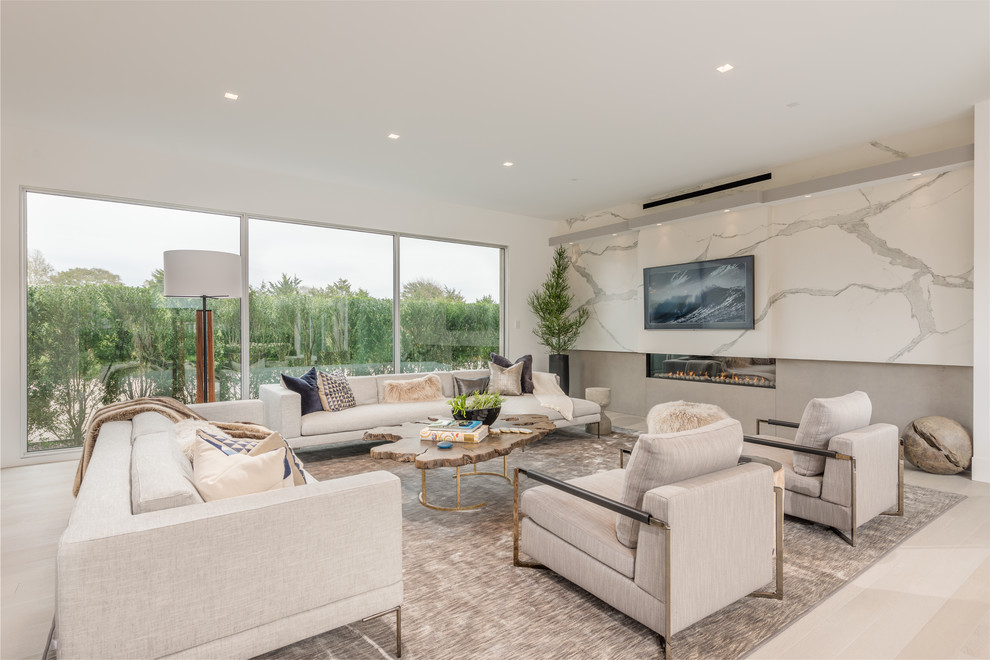 Photo of an expansive contemporary formal living room in New York with light hardwood floors, a ribbon fireplace, a concrete fireplace surround and beige floor.