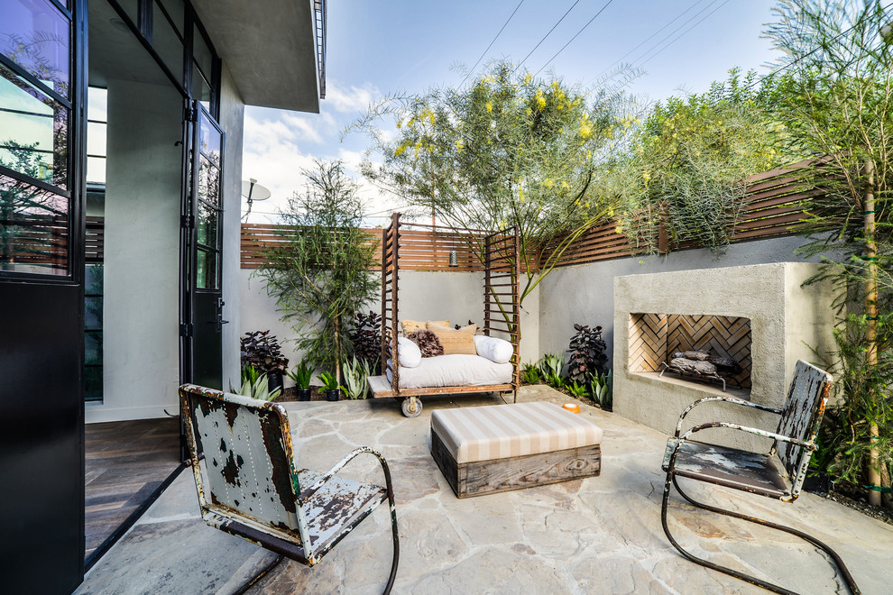 Industrial backyard patio in Los Angeles with a fire feature and no cover.