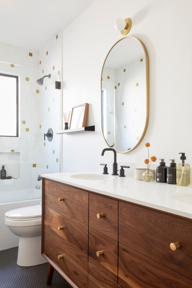 Exempel på ett litet 60 tals vit vitt badrum med dusch, med släta luckor, bruna skåp, ett badkar i en alkov, en dusch/badkar-kombination, gul kakel, keramikplattor, vita väggar, klinkergolv i porslin, ett undermonterad handfat, bänkskiva i kvarts och svart golv