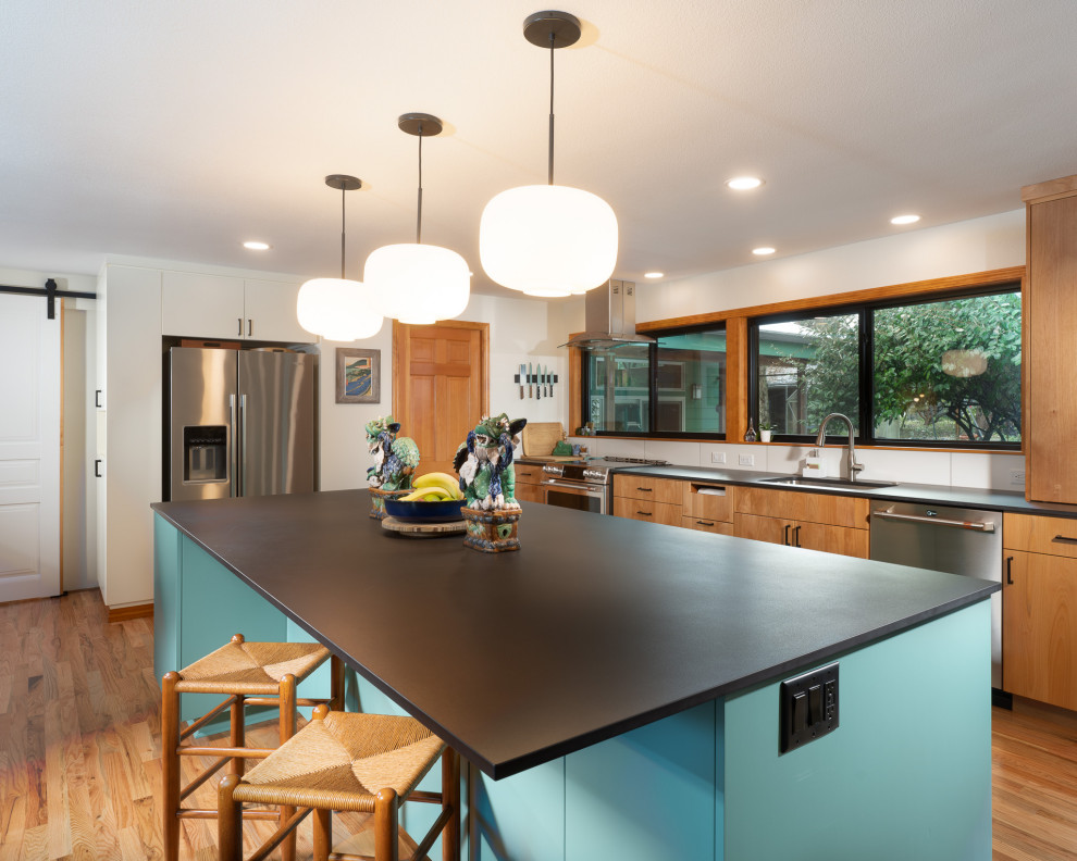 Design ideas for a large modern eat-in kitchen in Other with an undermount sink, shaker cabinets, blue cabinets, quartzite benchtops, white splashback, ceramic splashback, stainless steel appliances, medium hardwood floors, with island and black benchtop.