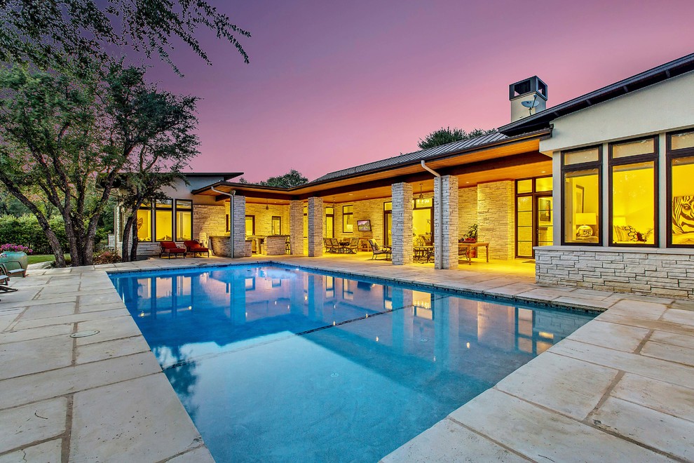 This is an example of a contemporary backyard rectangular lap pool in Austin.