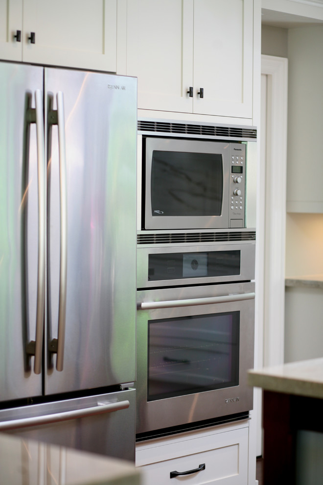 Eat-in kitchen - large transitional l-shaped dark wood floor and brown floor eat-in kitchen idea in Toronto with an undermount sink, shaker cabinets, white cabinets, stainless steel appliances and an island