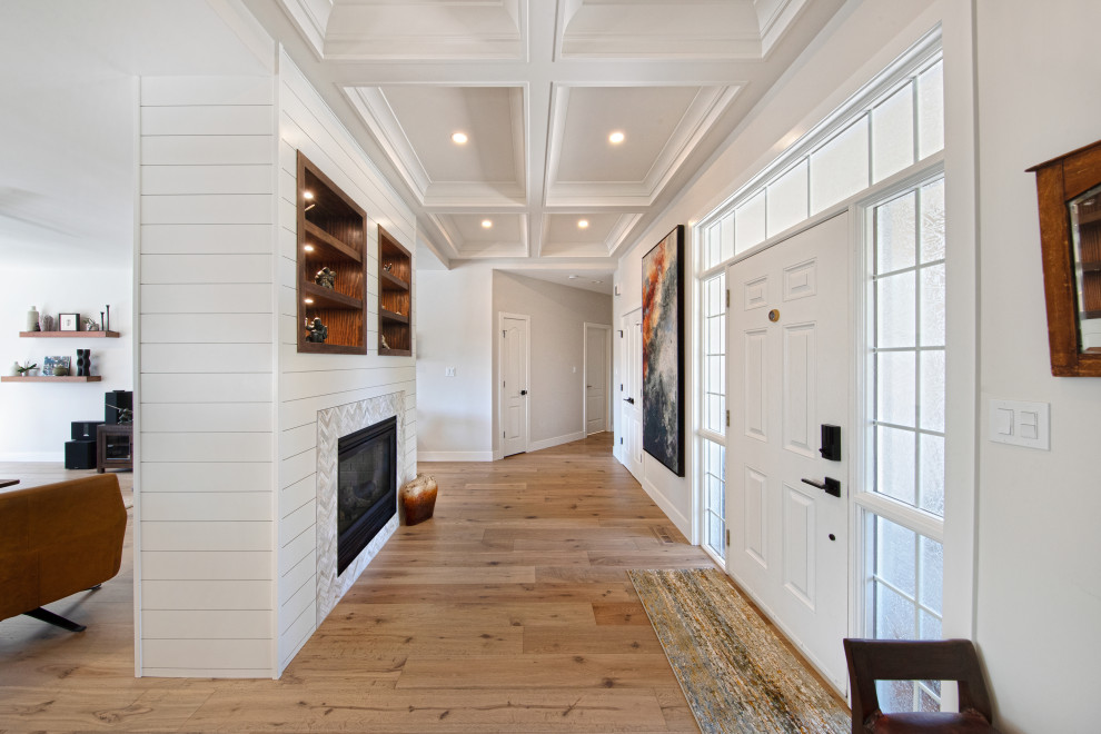 This is an example of a large country foyer in Edmonton with white walls, vinyl floors, a single front door, a white front door, brown floor and coffered.