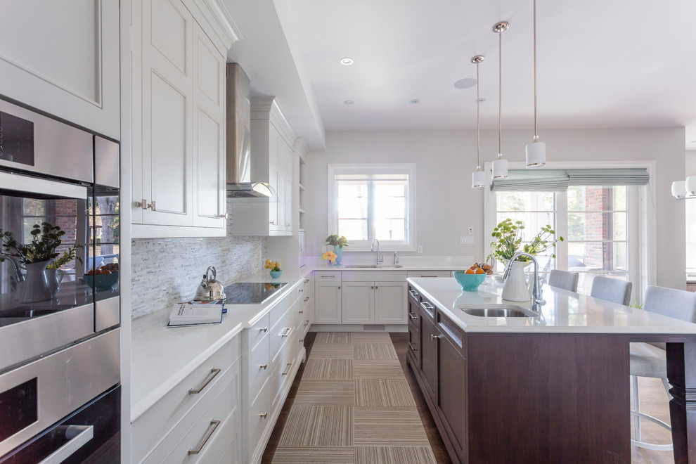 Transitional u-shaped medium tone wood floor eat-in kitchen photo in Toronto with an undermount sink, recessed-panel cabinets, white cabinets, quartz countertops, white backsplash, stone tile backsplash, stainless steel appliances and an island