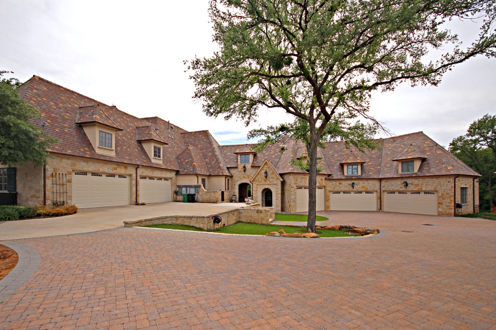 Expansive traditional two-storey stucco beige house exterior in Dallas with a tile roof.