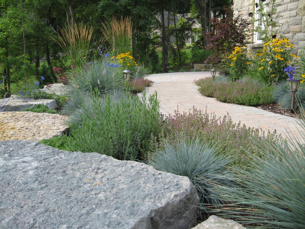 Photo of a mid-sized traditional front yard partial sun xeriscape for summer in Toronto with a garden path and brick pavers.