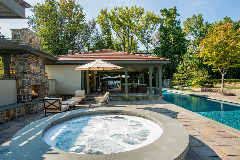Large traditional backyard rectangular lap pool in New York with a hot tub and concrete pavers.