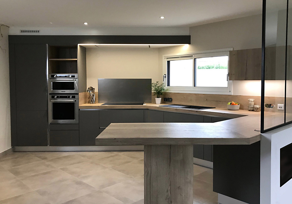 Inspiration for a large modern l-shaped open plan kitchen in Nantes with a single-bowl sink, beaded inset cabinets, laminate benchtops, timber splashback and stainless steel appliances.