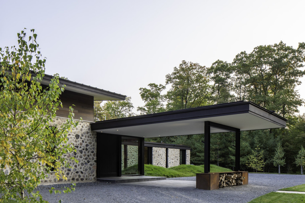 Imagen de fachada de casa negra rústica grande de dos plantas con tejado plano