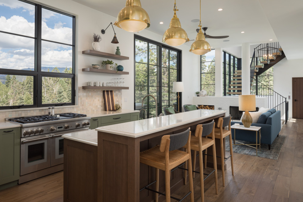 Design ideas for a transitional galley kitchen in Denver with shaker cabinets, green cabinets, beige splashback, stainless steel appliances, medium hardwood floors, with island, brown floor and white benchtop.