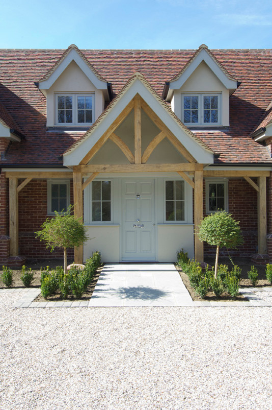 This is an example of a contemporary entryway in Essex with a single front door and a light wood front door.
