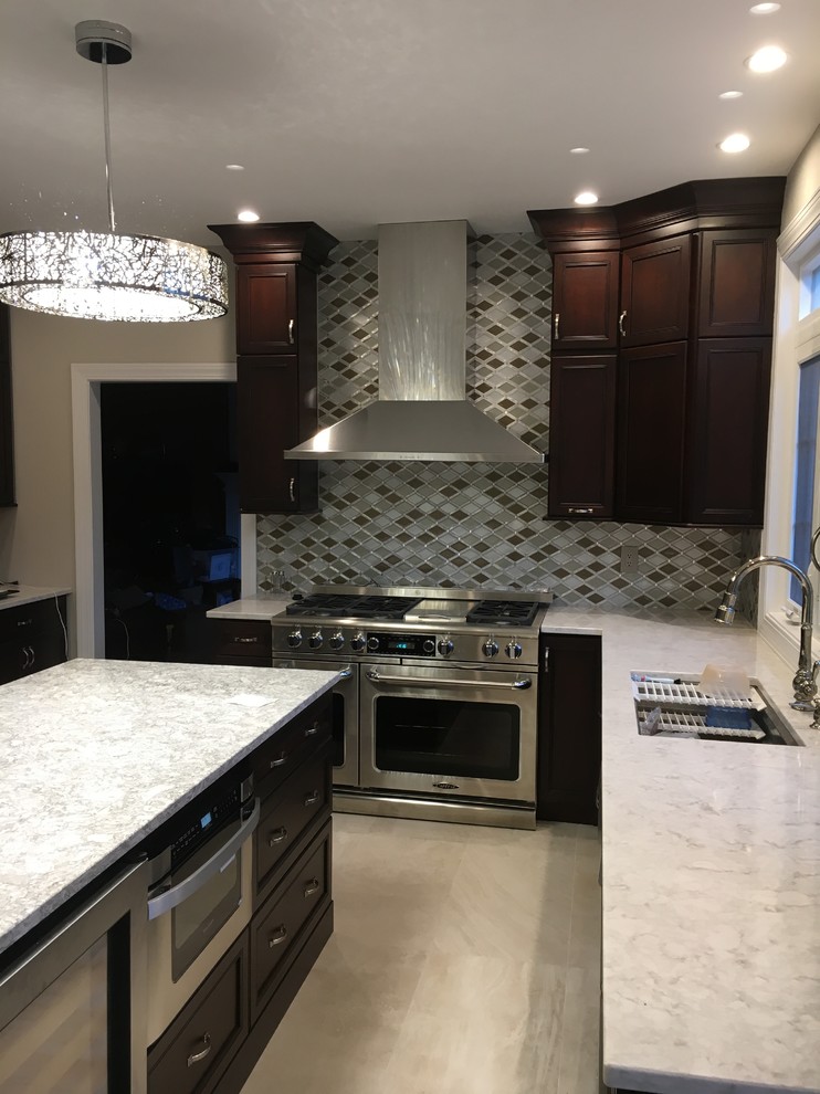 Kitchen - mid-sized transitional l-shaped porcelain tile and beige floor kitchen idea in New York with an undermount sink, recessed-panel cabinets, dark wood cabinets, quartzite countertops, multicolored backsplash, porcelain backsplash, stainless steel appliances and an island