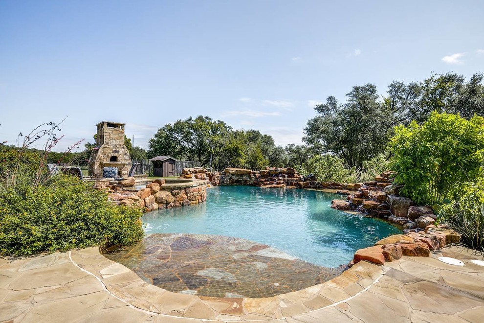Large mountain style backyard stone and custom-shaped natural hot tub photo in Austin