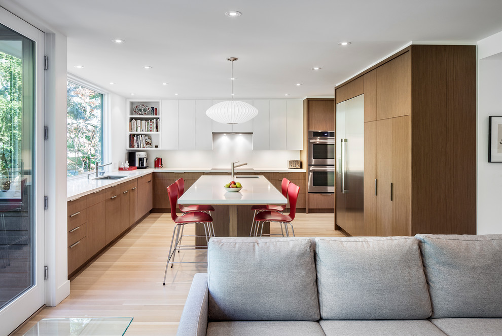 Design ideas for a contemporary l-shaped open plan kitchen in Toronto with an undermount sink, flat-panel cabinets, dark wood cabinets, quartz benchtops, white splashback, glass sheet splashback, stainless steel appliances, light hardwood floors and with island.