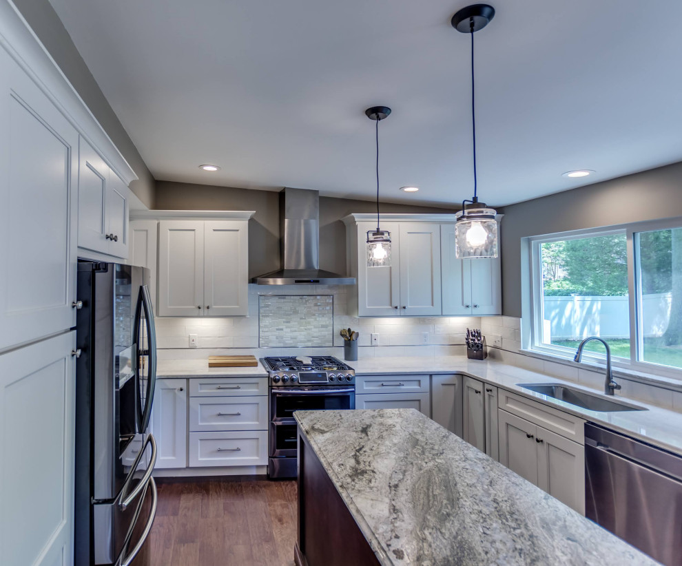 Eat-in kitchen - mid-sized transitional u-shaped brown floor eat-in kitchen idea in St Louis with white cabinets, granite countertops, white backsplash, subway tile backsplash, stainless steel appliances, an island and multicolored countertops