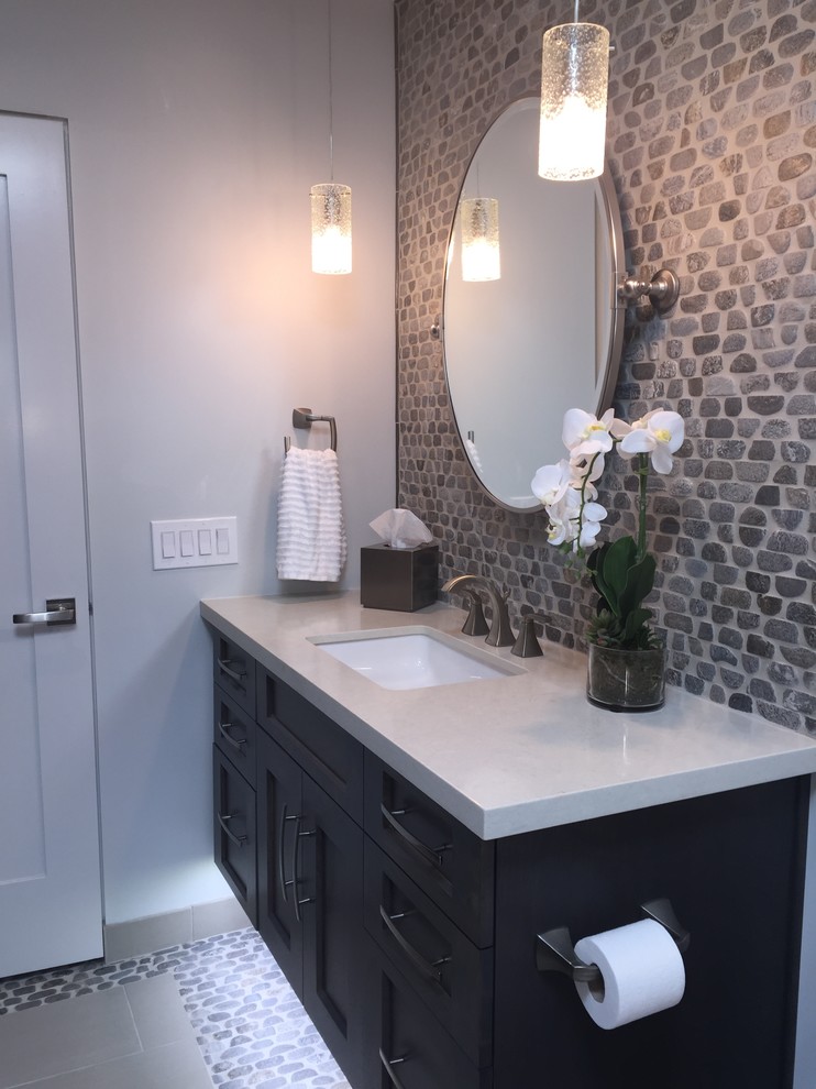 This is an example of a mid-sized transitional bathroom in Phoenix with an undermount sink, shaker cabinets, dark wood cabinets, engineered quartz benchtops, an alcove tub, a shower/bathtub combo, gray tile, pebble tile, pebble tile floors and multi-coloured walls.