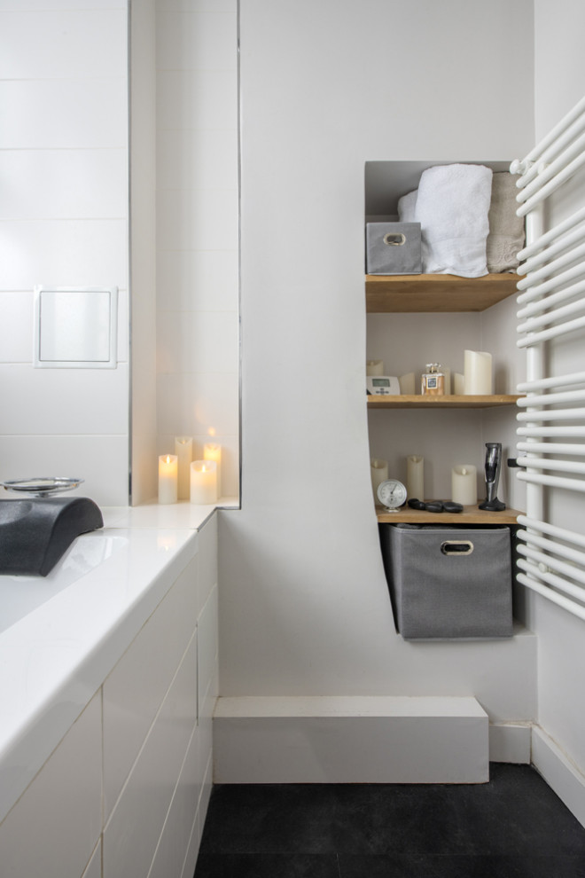 Photo of a small contemporary master wet room bathroom in Paris with flat-panel cabinets, medium wood cabinets, an undermount tub, white tile, cement tile, white walls, cement tiles, a trough sink, black floor, a shower curtain, white benchtops, a niche, a single vanity and a floating vanity.