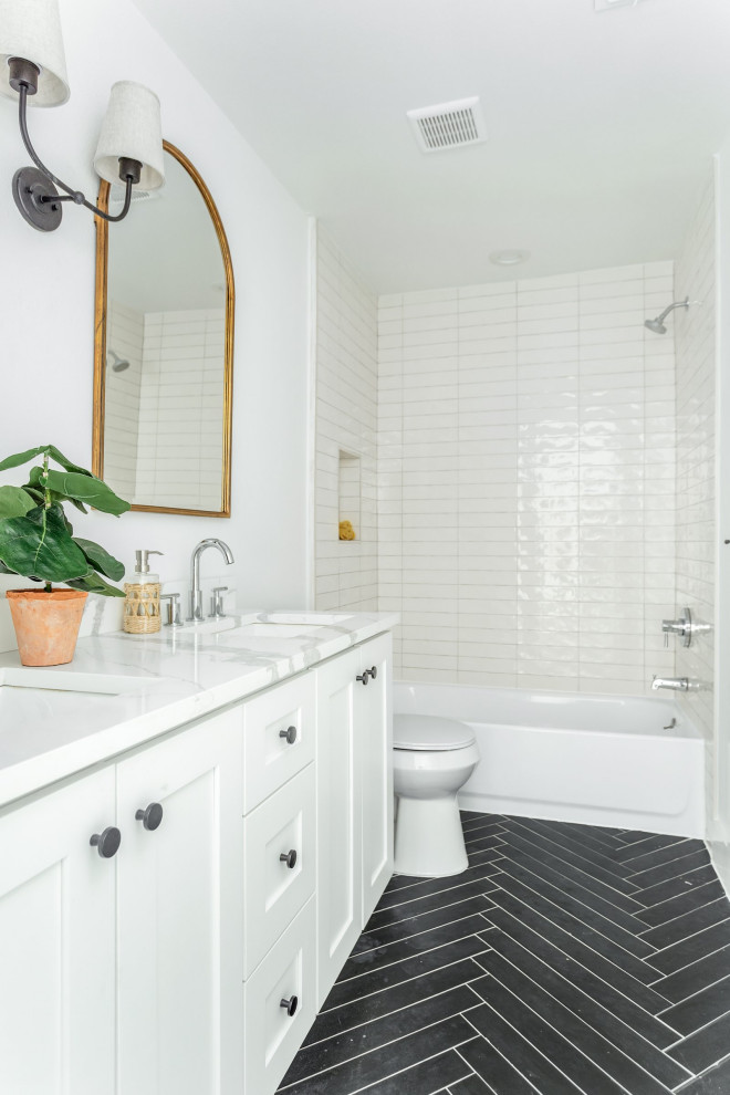 Inspiration for an expansive coastal family bathroom in Dallas with shaker cabinets, white cabinets, an alcove bath, a shower/bath combination, white tiles, stone tiles, white walls, porcelain flooring, a submerged sink, quartz worktops, black floors, a shower curtain, white worktops, double sinks and a built in vanity unit.