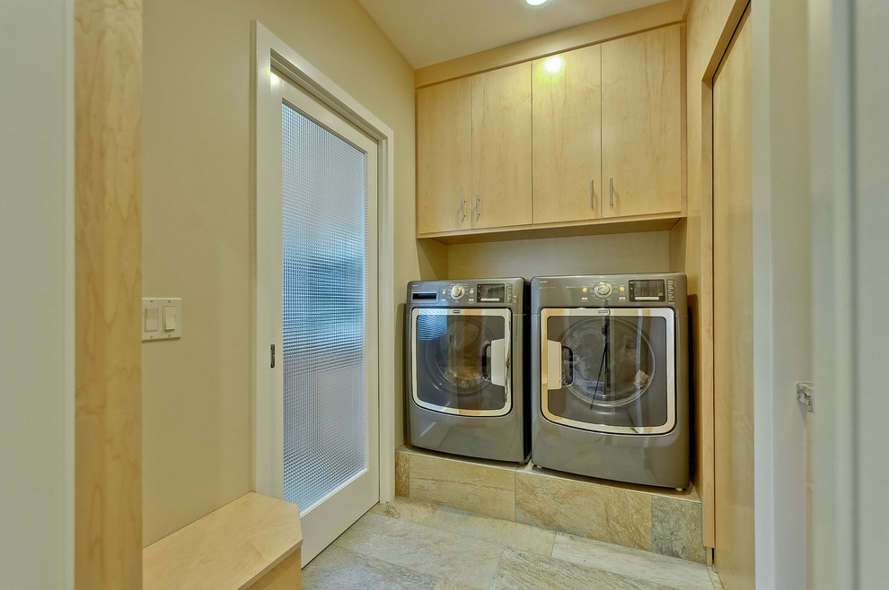 Large midcentury laundry room in San Francisco with flat-panel cabinets, light wood cabinets, slate floors, beige floor and beige walls.