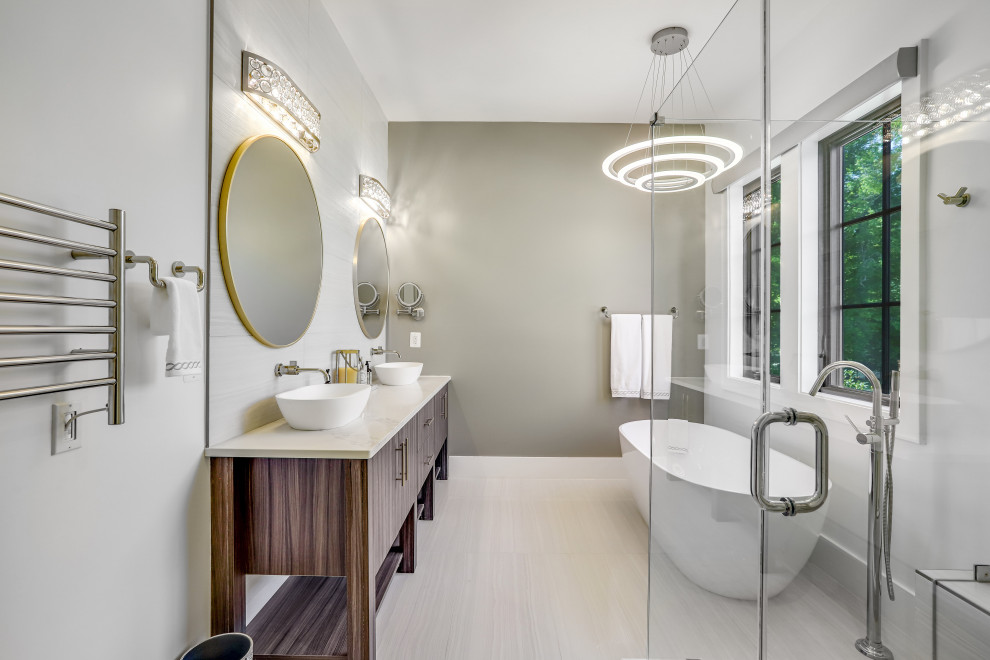 Photo of a large transitional master bathroom in DC Metro with flat-panel cabinets, medium wood cabinets, a freestanding tub, a corner shower, white tile, a vessel sink, engineered quartz benchtops, a hinged shower door, a shower seat, a double vanity and a freestanding vanity.
