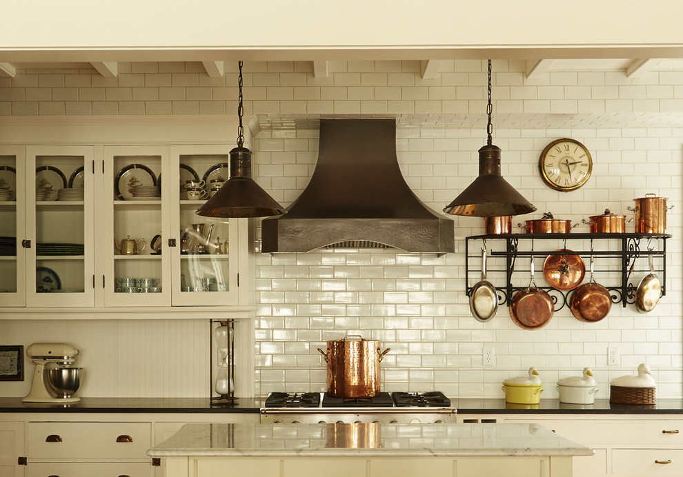 Inspiration for a timeless kitchen remodel in Milwaukee with glass-front cabinets, white cabinets, white backsplash, subway tile backsplash and an island