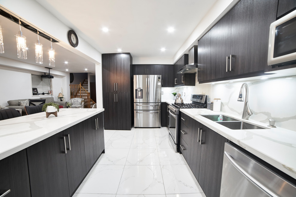 Photo of a medium sized contemporary l-shaped kitchen/diner in Toronto with a double-bowl sink, flat-panel cabinets, brown cabinets, engineered stone countertops, white splashback, engineered quartz splashback, stainless steel appliances, porcelain flooring, an island, white floors and white worktops.