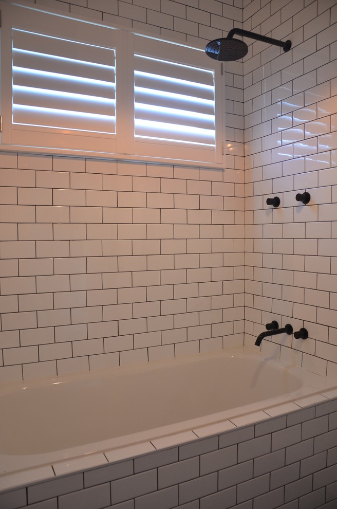 Inspiration for a contemporary bathroom in Sydney with a vessel sink, an alcove tub, a shower/bathtub combo, a one-piece toilet, flat-panel cabinets, white cabinets, wood benchtops, white tile and ceramic tile.